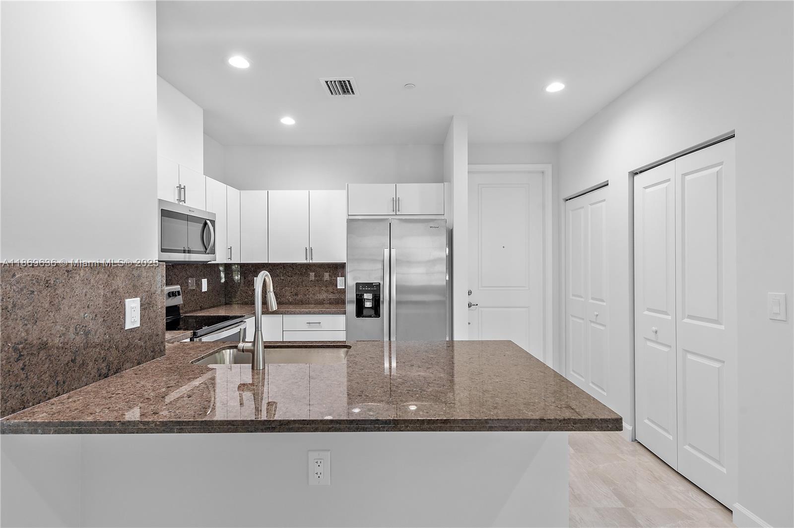5750 Southwest 44th Street, Unit 201 Davie, FL 33314 - Photo 11 of 26 a view of a kitchen with a sink a microwave and cabinets