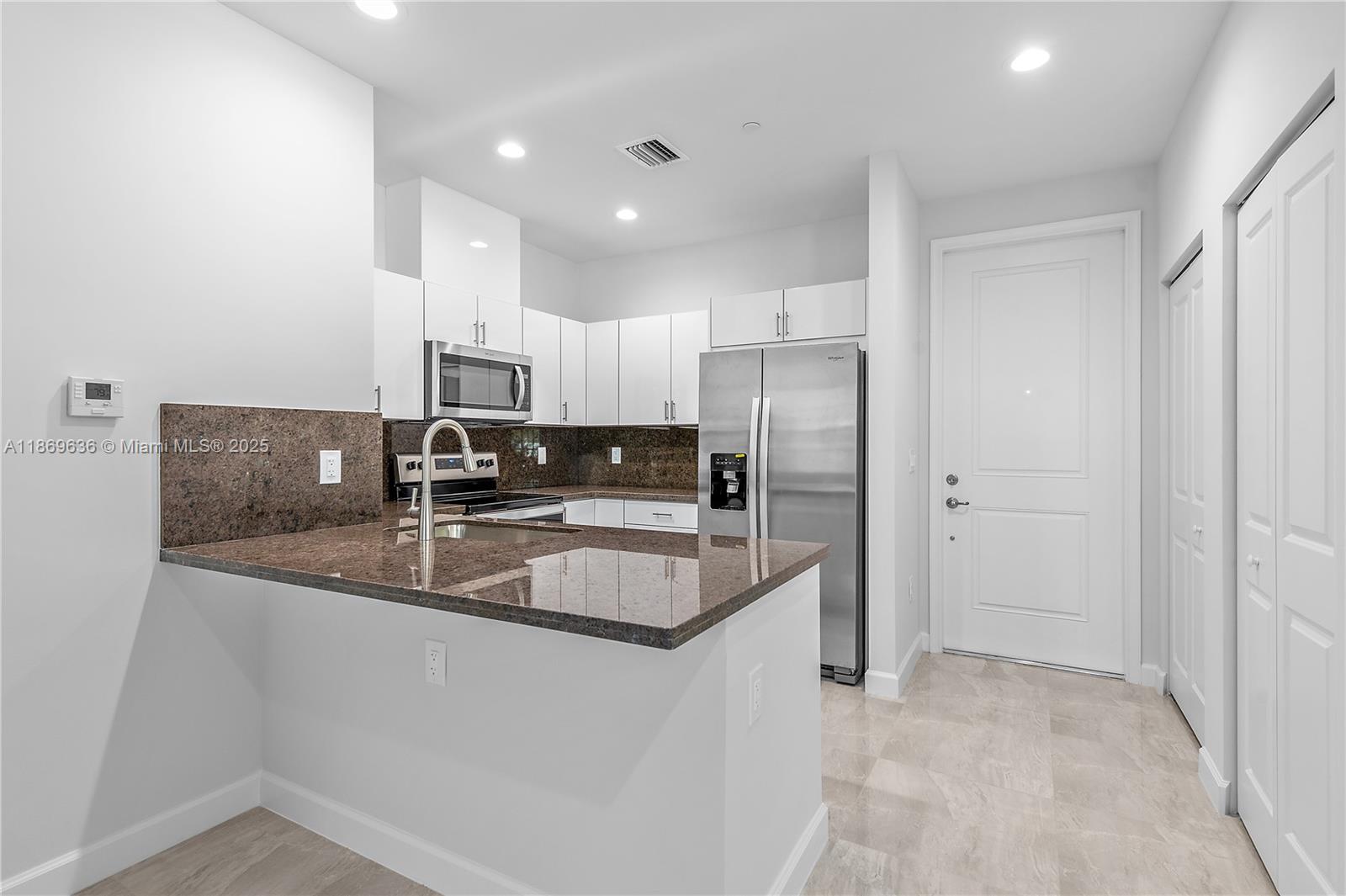 5750 Southwest 44th Street, Unit 201 Davie, FL 33314 - Photo 12 of 26 a kitchen with stainless steel appliances granite countertop a sink refrigerator and cabinets