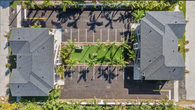 an aerial view of a house with a yard potted plants and large tree
