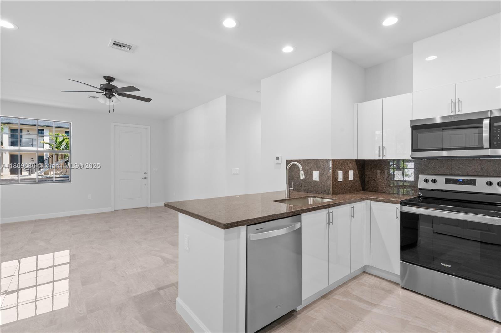 5750 Southwest 44th Street, Unit 201 Davie, FL 33314 - Photo 8 of 26 a kitchen with stainless steel appliances granite countertop a stove and a sink