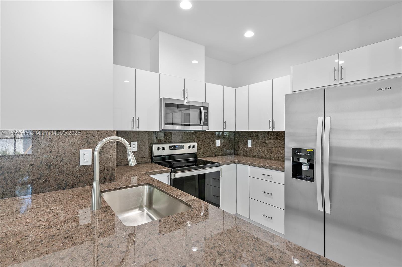 5750 Southwest 44th Street, Unit 201 Davie, FL 33314 - Photo 10 of 26 a kitchen with stainless steel appliances granite countertop a sink a stove a refrigerator cabinets and chairs