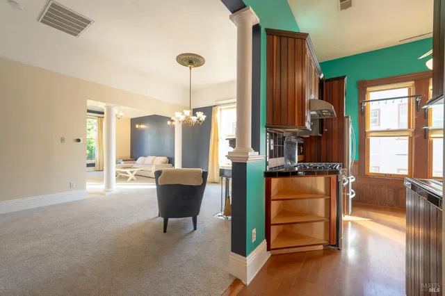 a living room with furniture a large window and wooden floor