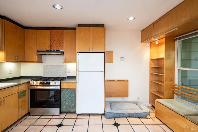 a kitchen with a refrigerator a stove top oven