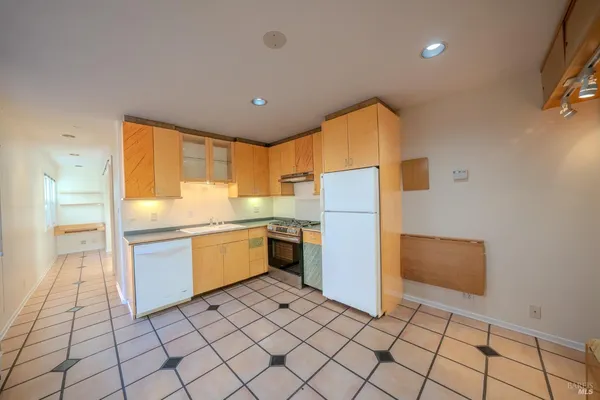 a kitchen with a refrigerator sink and cabinets