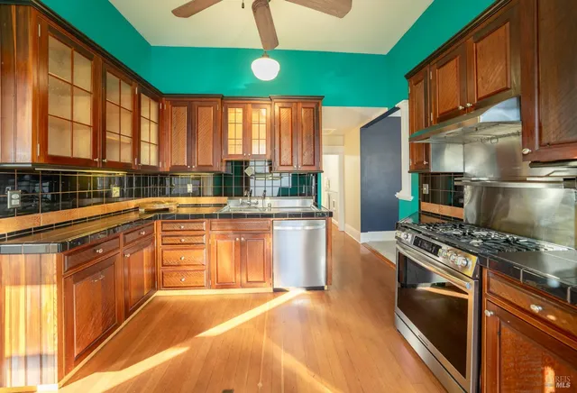 a kitchen with stainless steel appliances granite countertop a sink a stove and a refrigerator