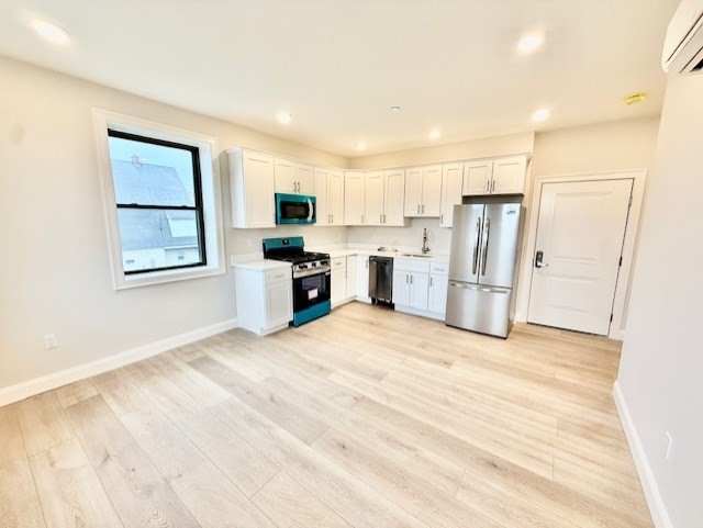 a view of kitchen with stainless steel appliances refrigerator stove microwave and cabinets