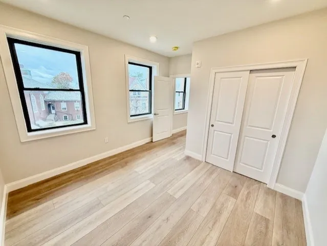 a view of an empty room with closet and a window