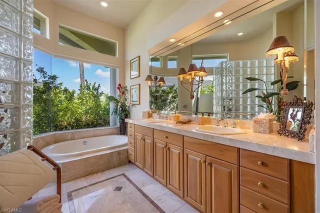 a bathroom with a tub sink and mirror