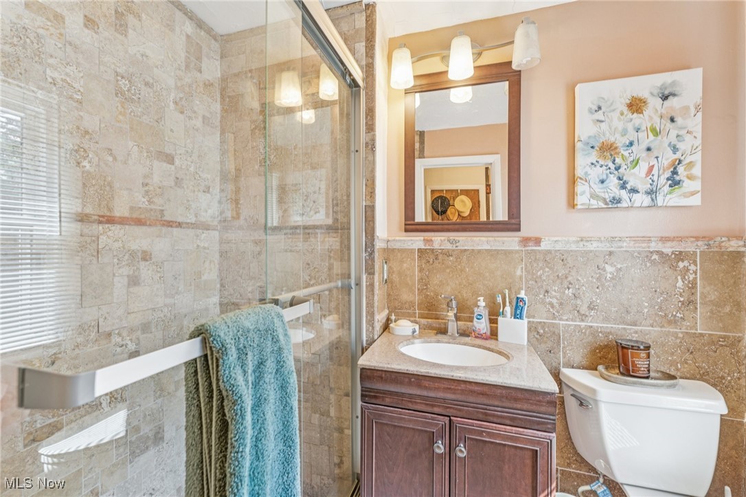 2911 Lee Road Cleveland, OH 44120 - Photo 38 of 50 Full bath featuring tile walls, vanity, and a stall shower