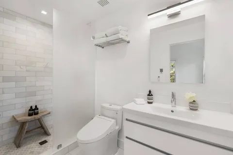 a bathroom with a sink mirror vanity and toilet