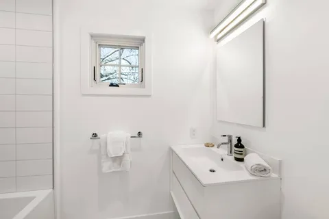 a bathroom with a sink a toilet and a mirror