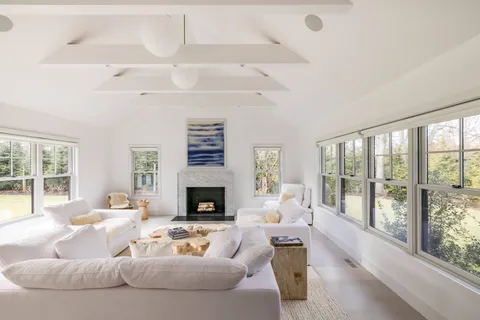 a living room with furniture large window and a fireplace