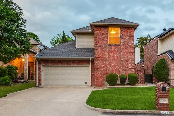 a front view of a house with a garden and yard