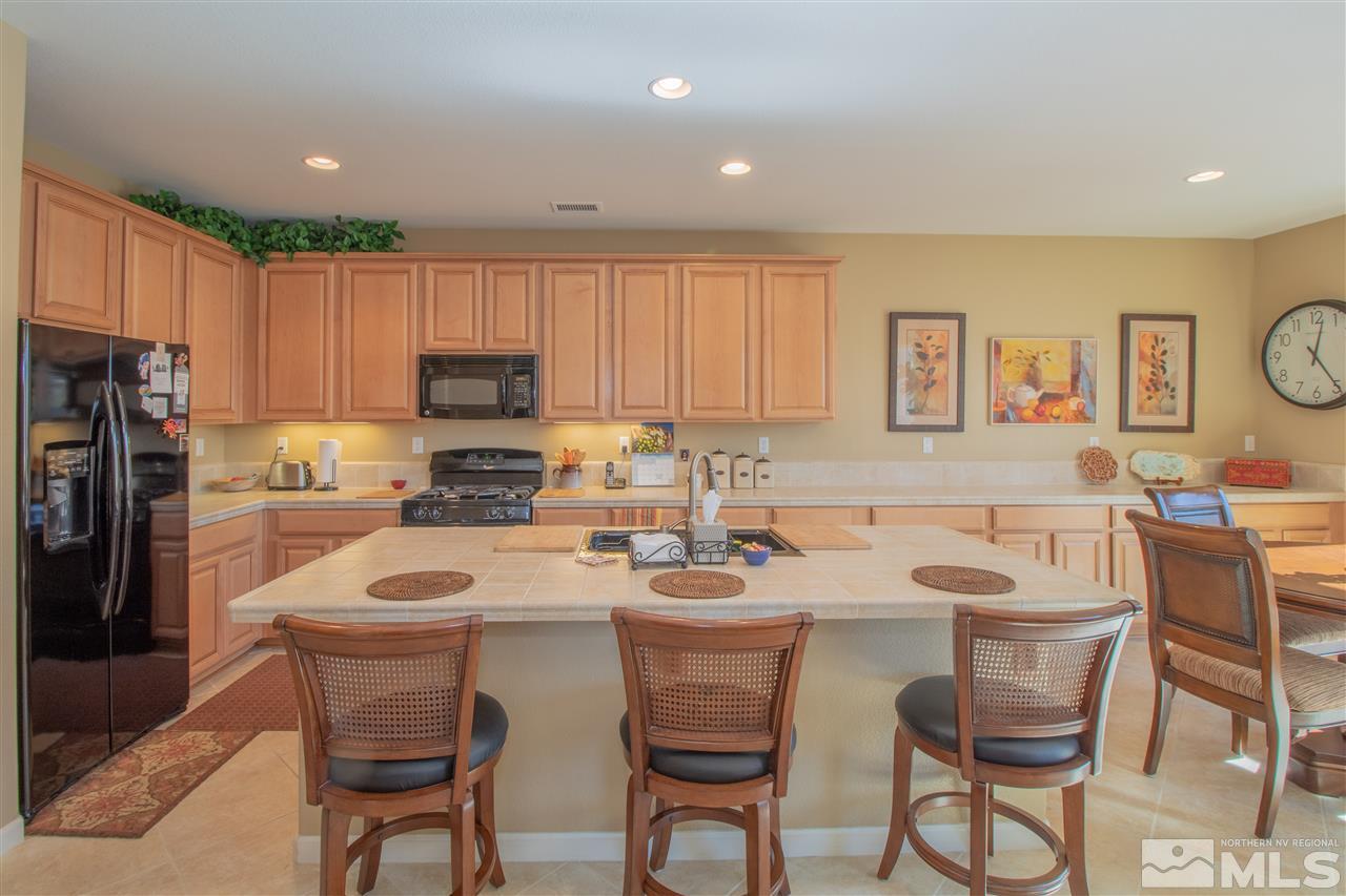 2000 Angel Ridge Drive Reno, NV 89521 - Photo 5 of 18 a kitchen with a dining table chairs refrigerator and cabinets
