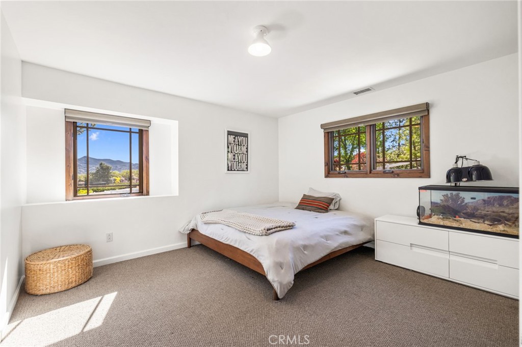 59353 Hop Patch Spring Road Mountain Center, CA 92561 - Photo 22 of 68 a bedroom with a bed and a painting on the wall