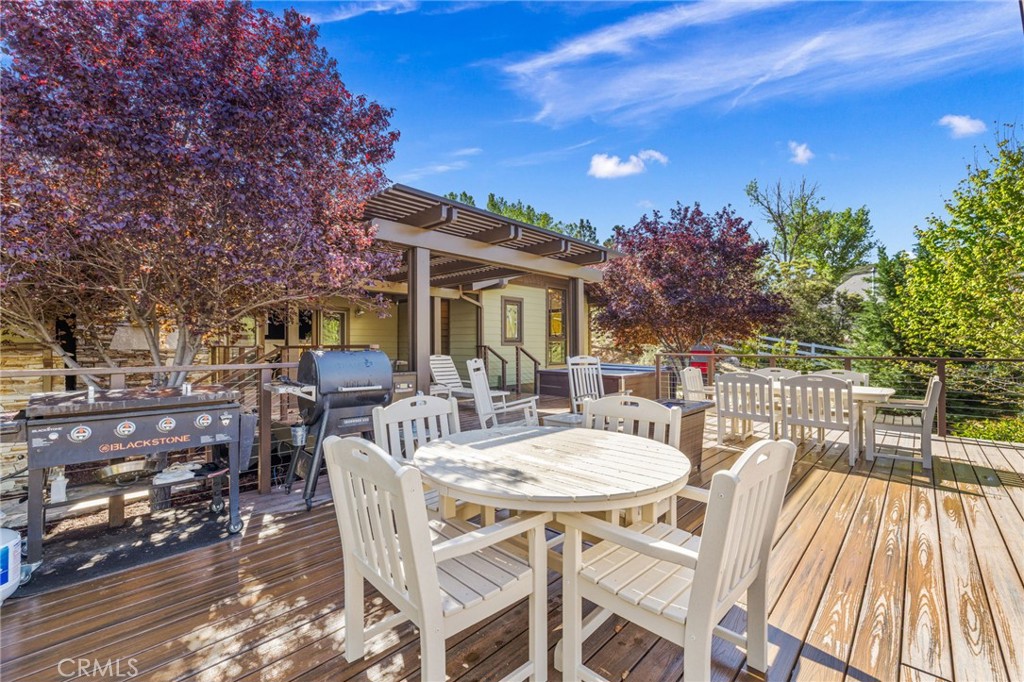 59353 Hop Patch Spring Road Mountain Center, CA 92561 - Photo 37 of 68 a view of a patio with table and chairs and potted plants with wooden floor and fence