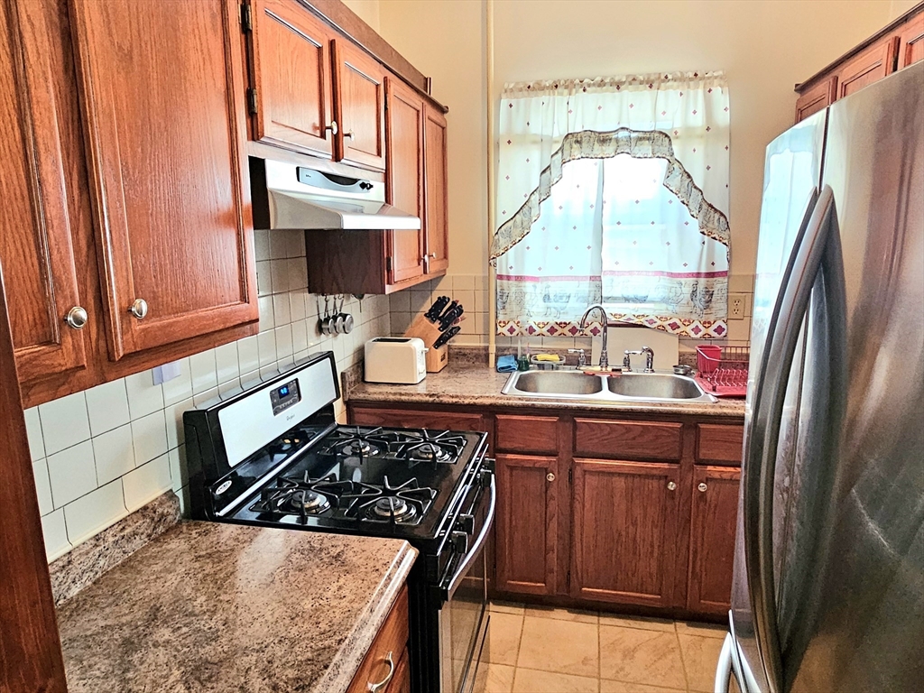 460 William Street Fall River, MA 02721 - Photo 4 of 23 a kitchen with stainless steel appliances a stove a refrigerator and a sink