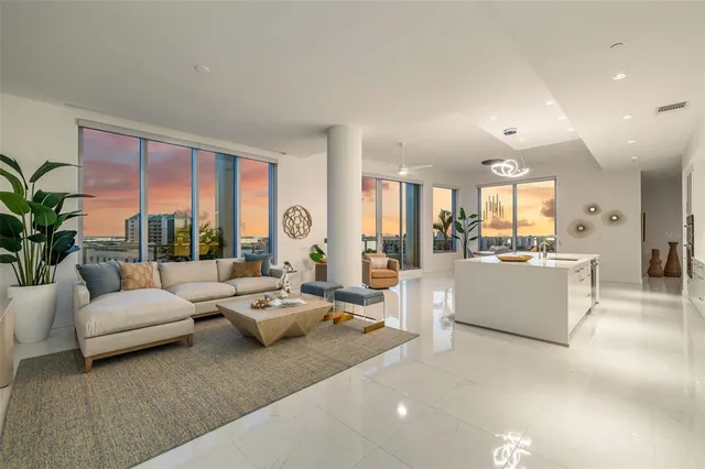 a large white kitchen with lots of counter top space and stainless steel appliances