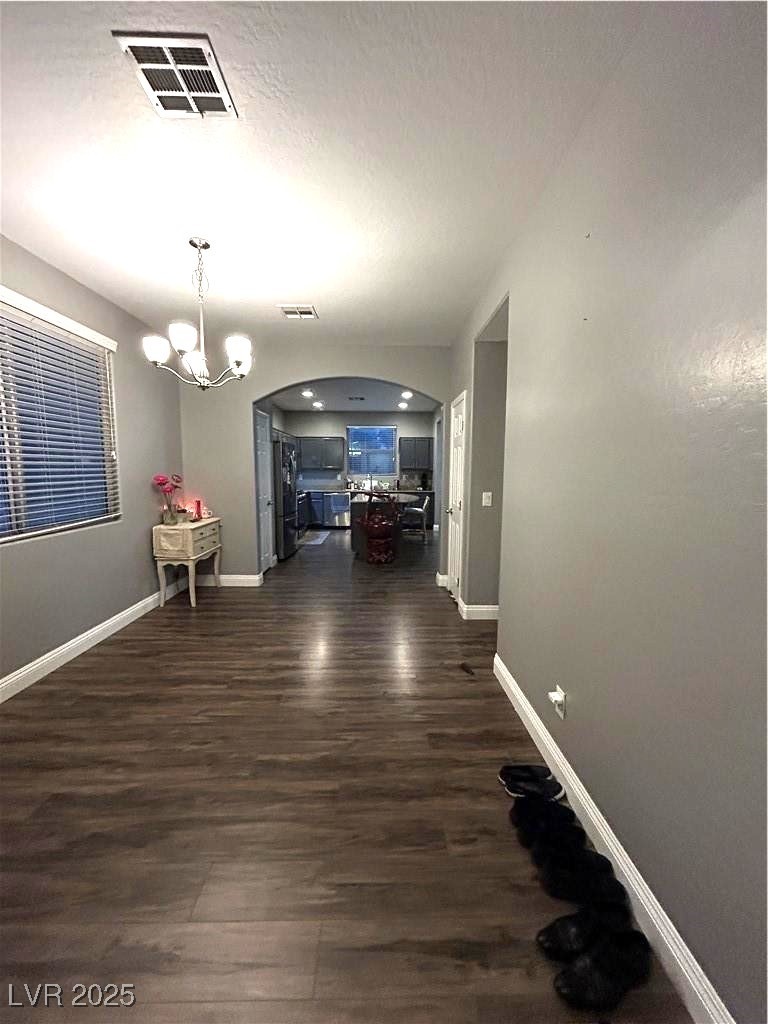 8977 Melridge Road Las Vegas, NV 89148 - Photo 24 of 35 Dining area with visible vents, arched walkways, baseboards, and dark wood-type flooring