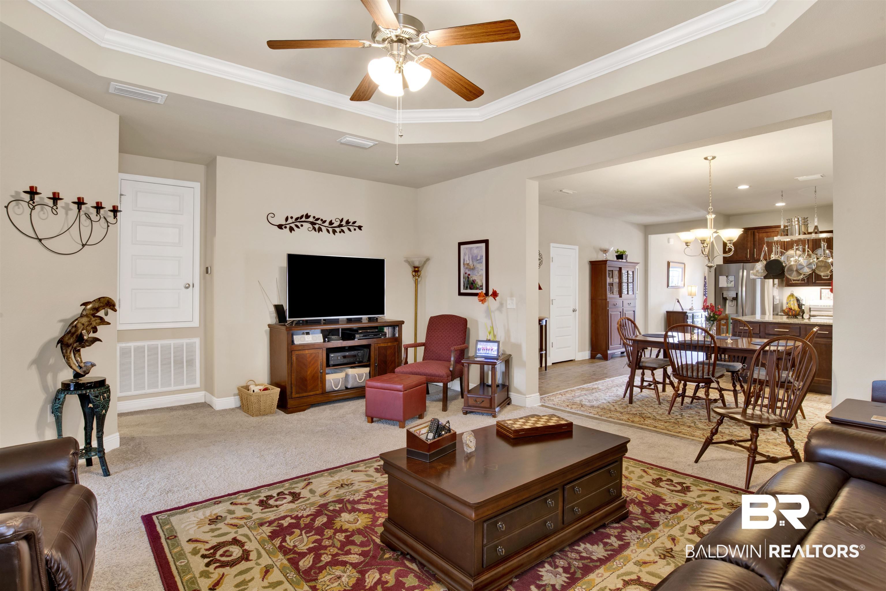 1476 Surrey Loop Foley, AL 36535 - Photo 19 of 31 Carpeted living room with a tray ceiling, ceiling fan with notable chandelier, and ornamental molding