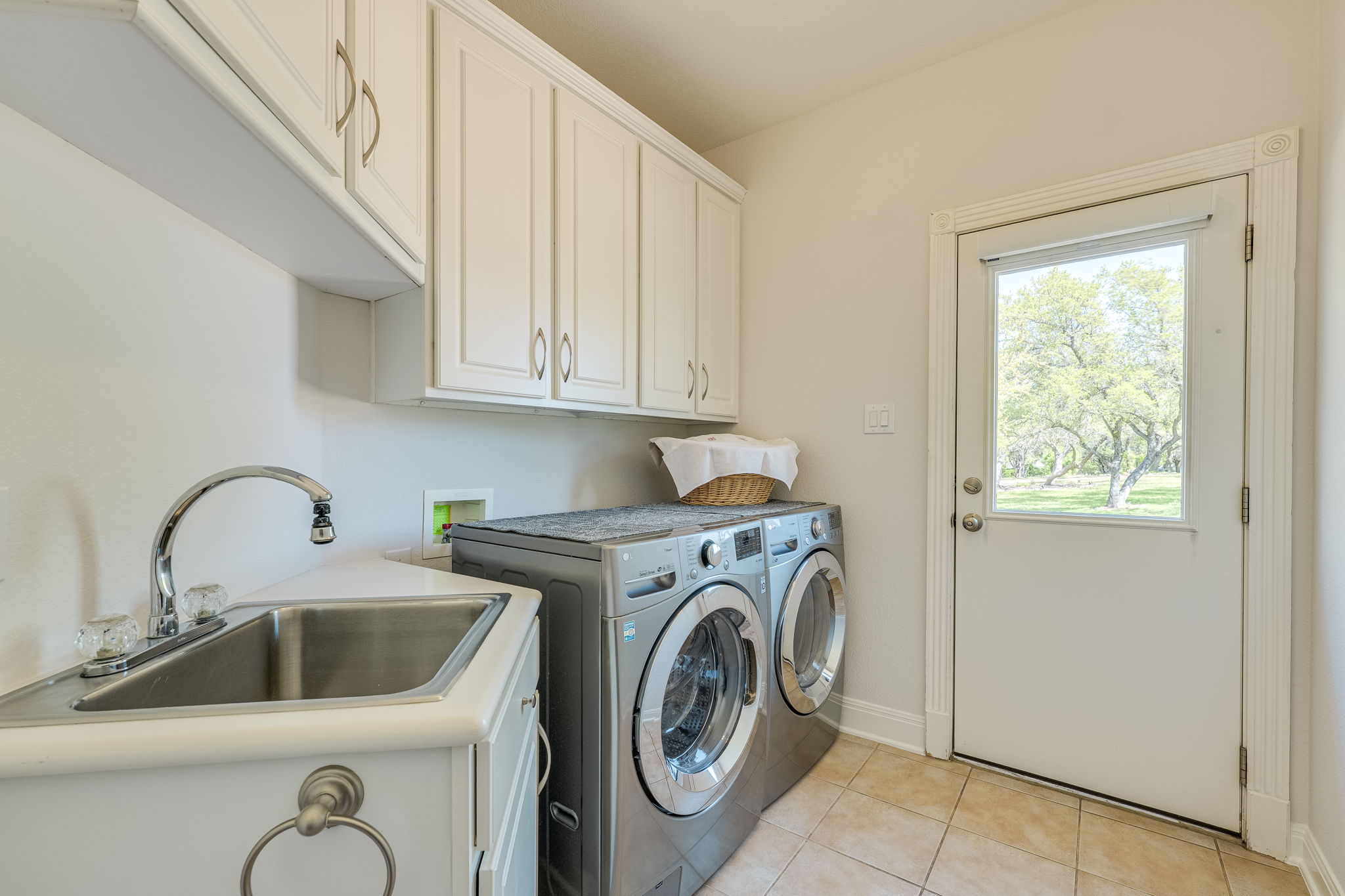 4424 Lago Viento Austin, TX 78734 - Photo 12 of 38 Laundry room has a sink, built in cabinets and access to the side of the home near the 3 car garage.
