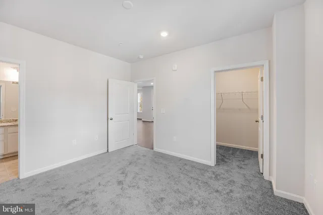 a spacious bathroom with a granite countertop sink toilet a mirror and a glass door shower