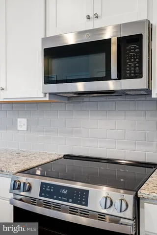 a stove top oven sitting inside of a kitchen
