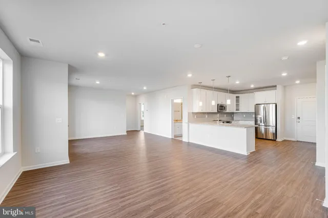 a view of kitchen with kitchen island sink refrigerator and window