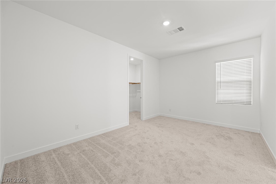9983 Decano Ridge Street Las Vegas, NV 89141 - Photo 27 of 39 Comfortable carpeted bedroom with a generous walk-in closet for ample storage.