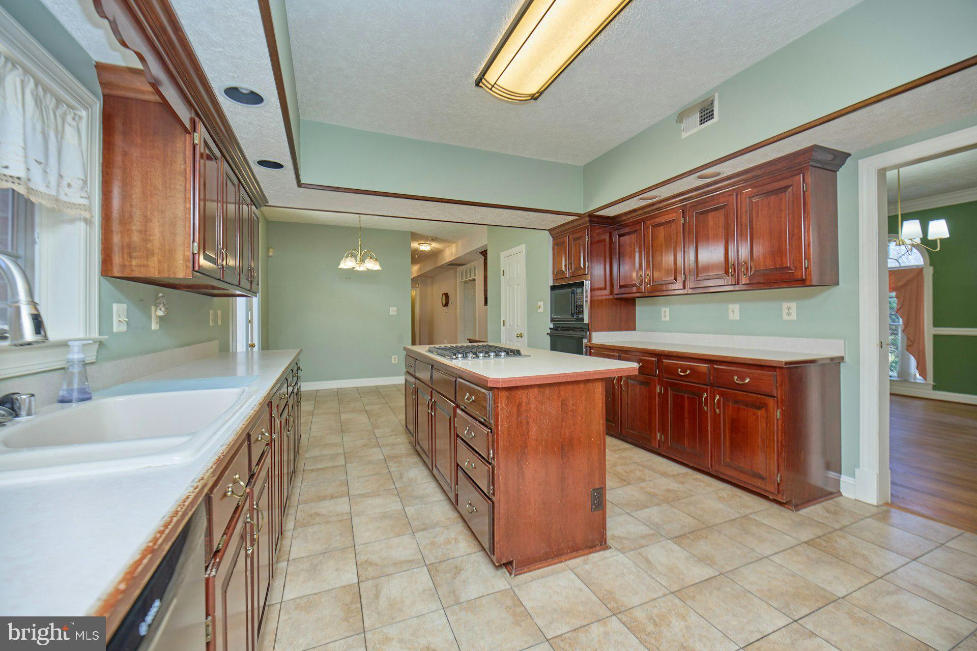6051 Adams Drive La Plata, MD 20646 - Photo 14 of 72 a large kitchen with kitchen island a sink a counter top space and cabinets