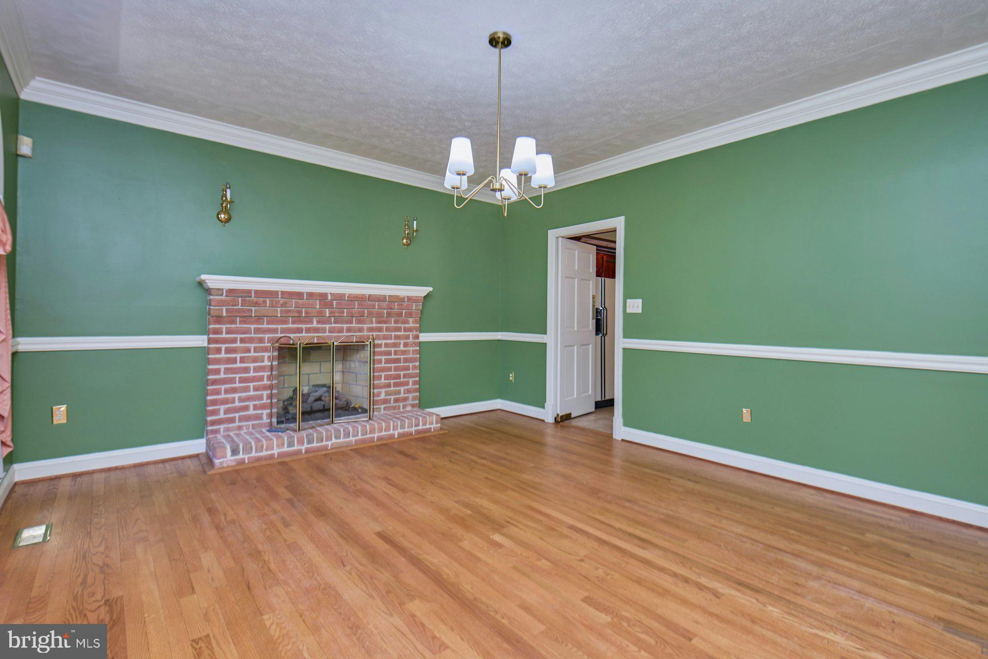 6051 Adams Drive La Plata, MD 20646 - Photo 19 of 72 a view of an empty room with a fireplace and a chandelier fan