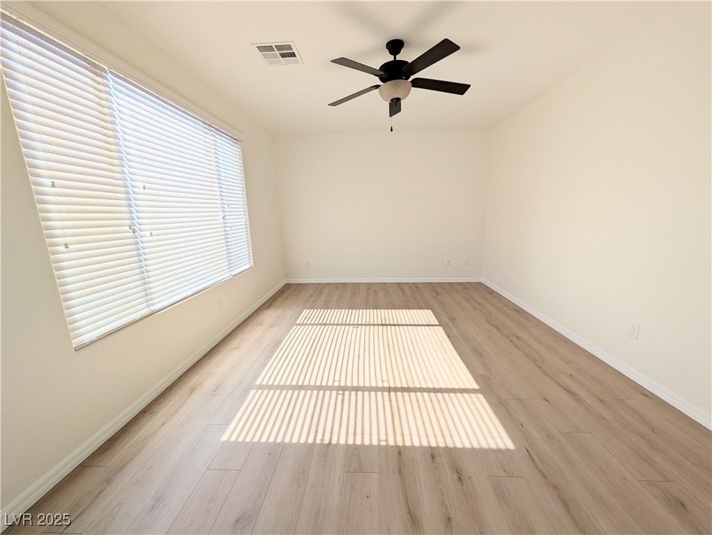 7011 Amapa Road Las Vegas, NV 89178 - Photo 12 of 32 Spare room featuring a ceiling fan and light wood-type flooring