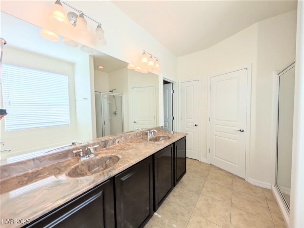 7011 Amapa Road Las Vegas, NV 89178 - Photo 13 of 32 Bathroom with a shower stall, double vanity, and light tile patterned floors