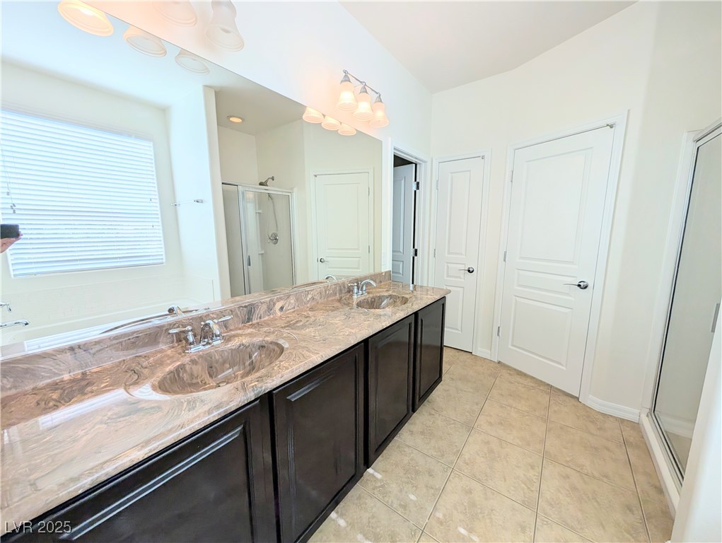 7011 Amapa Road Las Vegas, NV 89178 - Photo 14 of 32 Bathroom featuring a stall shower, light tile patterned floors, double vanity, and a garden tub