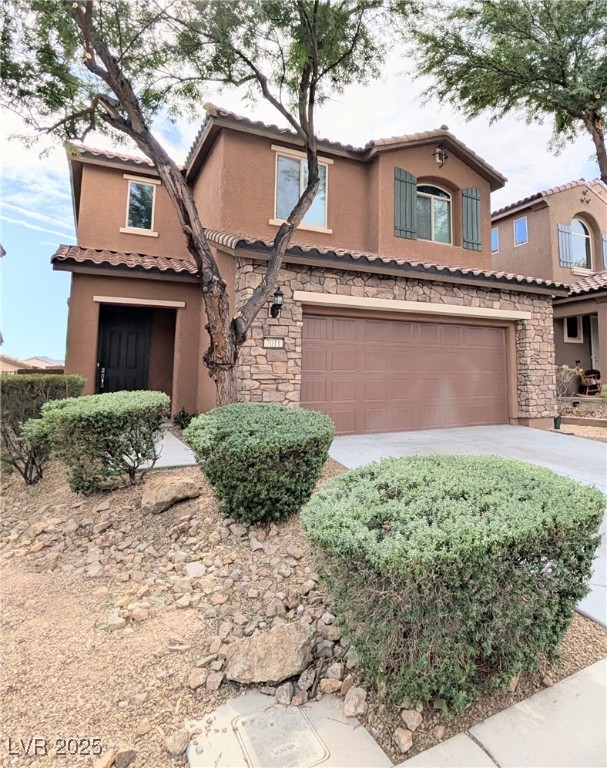 7011 Amapa Road Las Vegas, NV 89178 - Photo 2 of 32 Mediterranean / spanish home featuring stone siding, stucco siding, a tiled roof, and driveway
