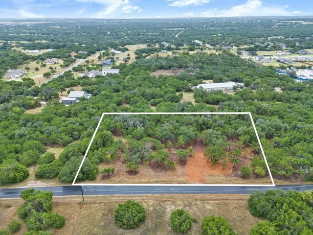 an aerial view of residential houses with outdoor space and street view