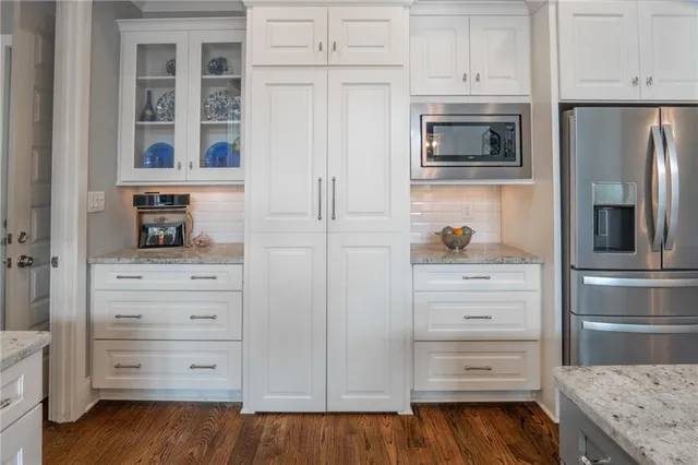 a kitchen with white cabinets and a refrigerator
