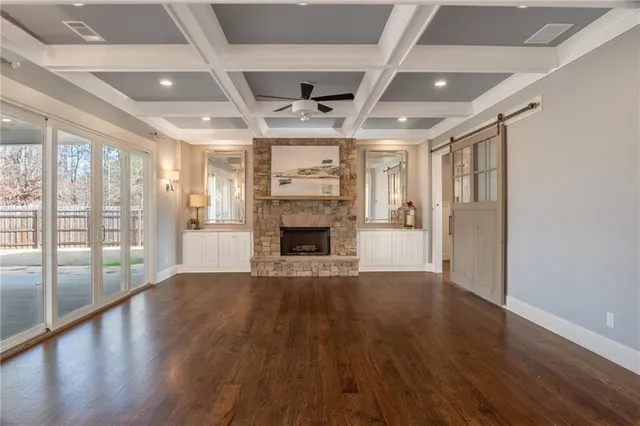 a view of an empty room with wooden floor and a fireplace