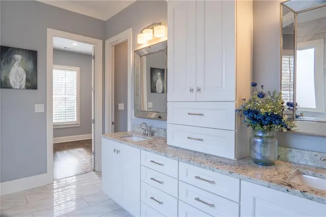 a bathroom with a granite countertop sink a potted plant and a window