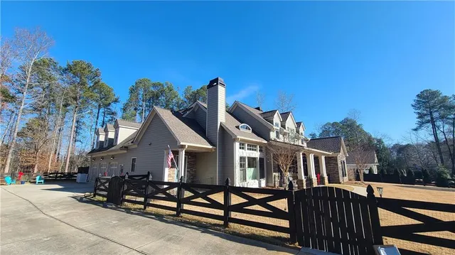 a view of a house with wooden deck and furniture