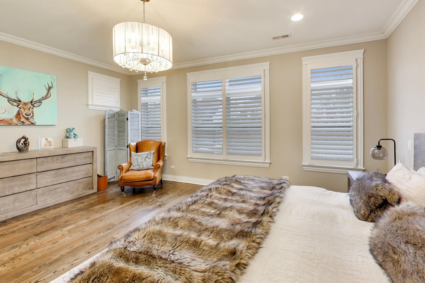 1226 West Henderson Street Chicago, IL 60657 - Photo 11 of 32 a spacious bedroom with a bed and a chandelier