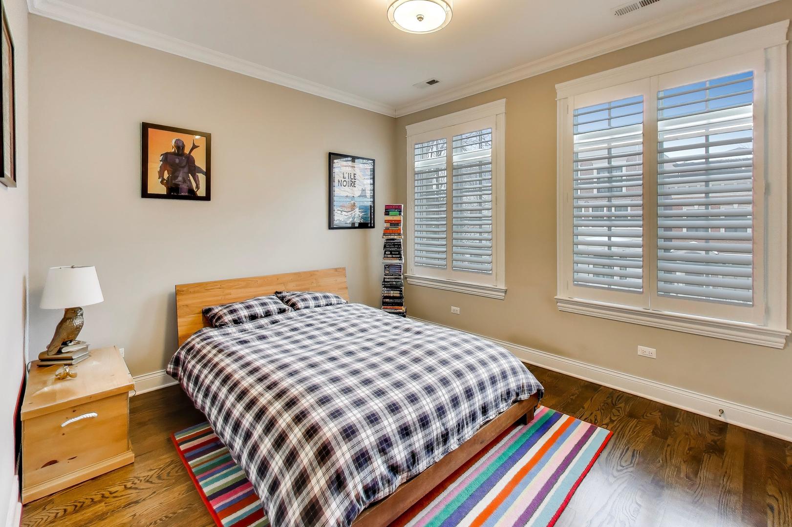 1226 West Henderson Street Chicago, IL 60657 - Photo 16 of 32 a bedroom with a bed and wooden floor