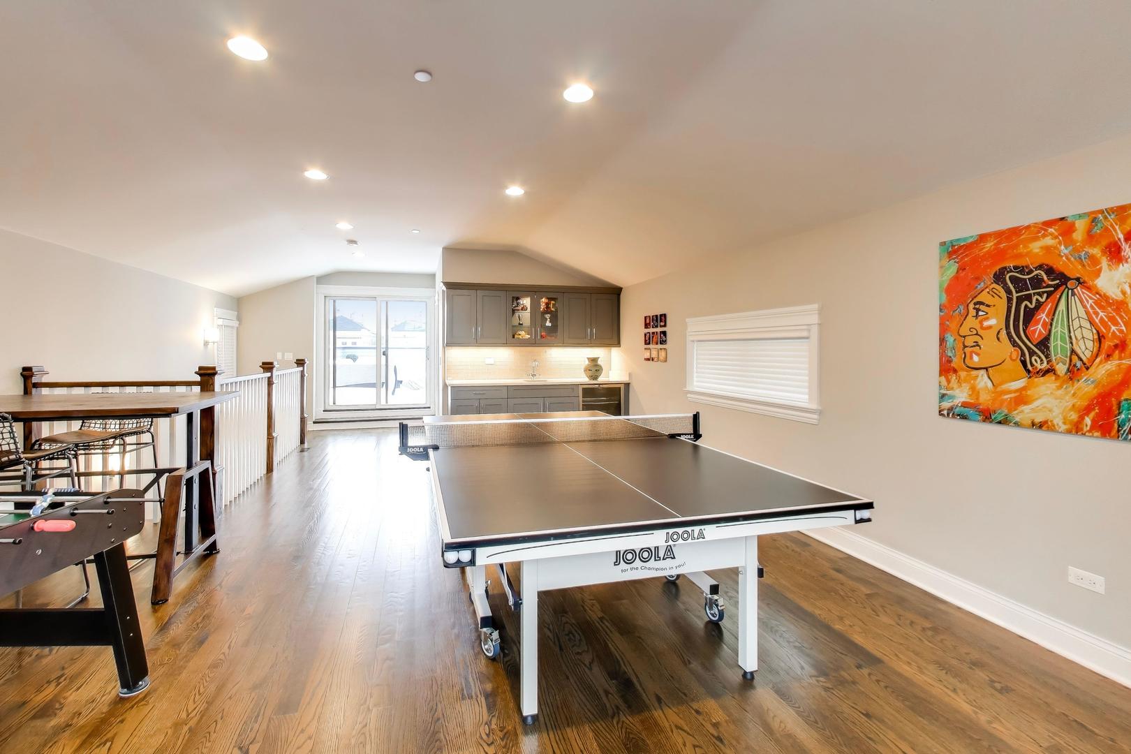 1226 West Henderson Street Chicago, IL 60657 - Photo 21 of 32 a kitchen with stainless steel appliances table chairs and wooden floor