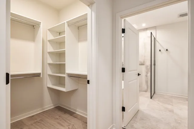 a view of walk in closet with empty racks