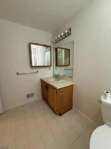 a bathroom with a sink a toilet and mirror