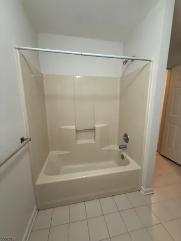 a white bath tub sitting next to a shower