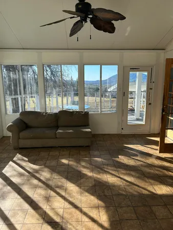 a living room with a bed furniture and next to a window