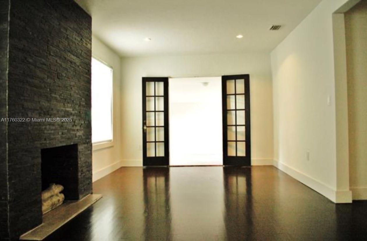 7020 Northeast 5th Avenue Miami, FL 33138 - Photo 37 of 42 a view of an empty room with wooden floor and a fireplace