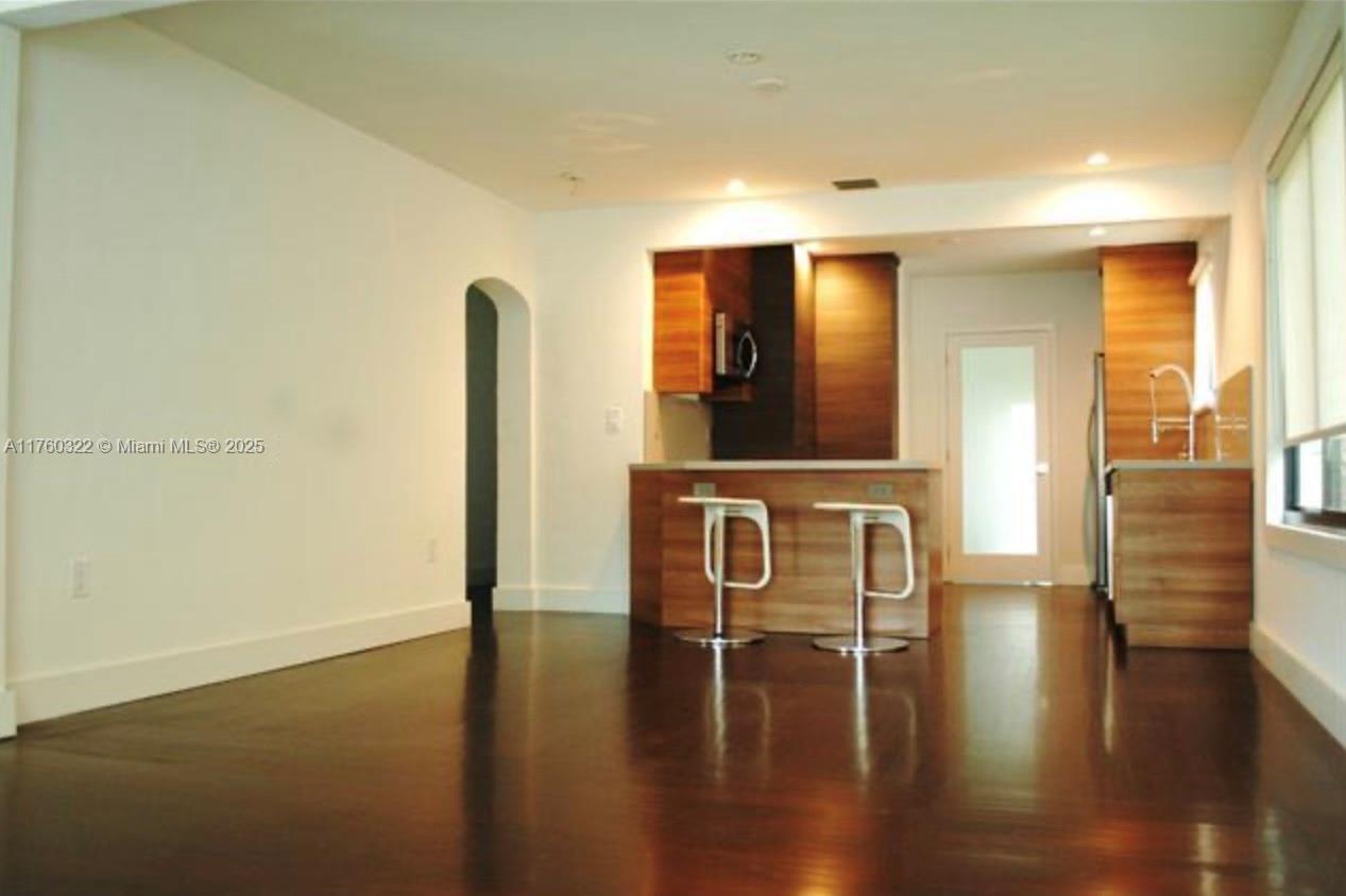7020 Northeast 5th Avenue Miami, FL 33138 - Photo 38 of 42 a hallway with wooden floor table and chairs