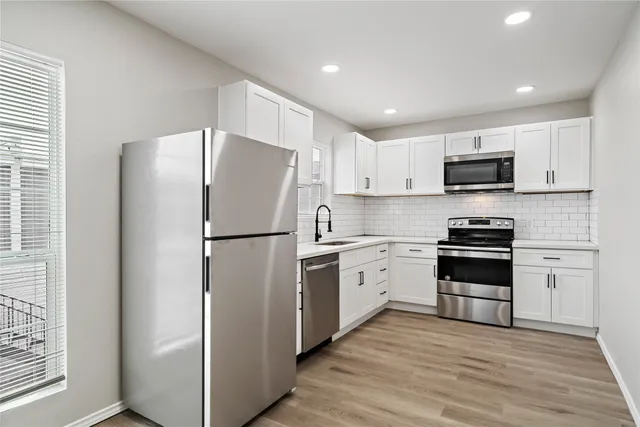 a kitchen with stainless steel appliances granite countertop a refrigerator stove a sink and a microwave